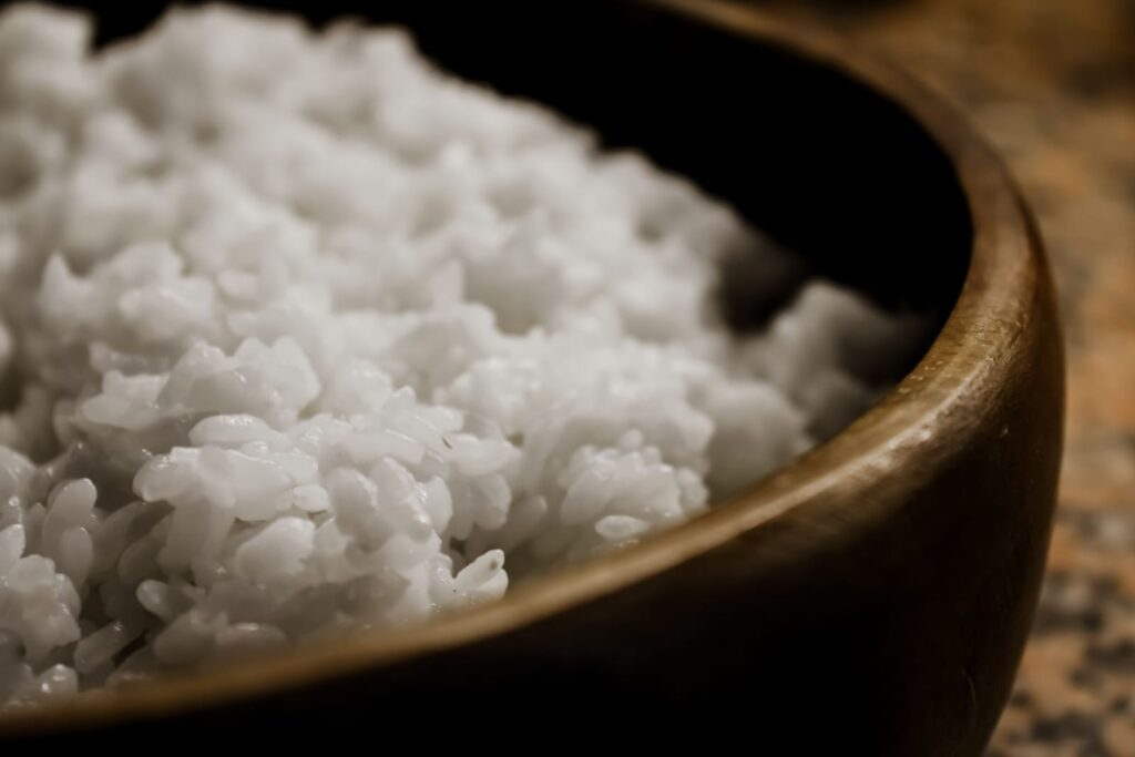 Close-up of freshly cooked white rice in a wooden bowl